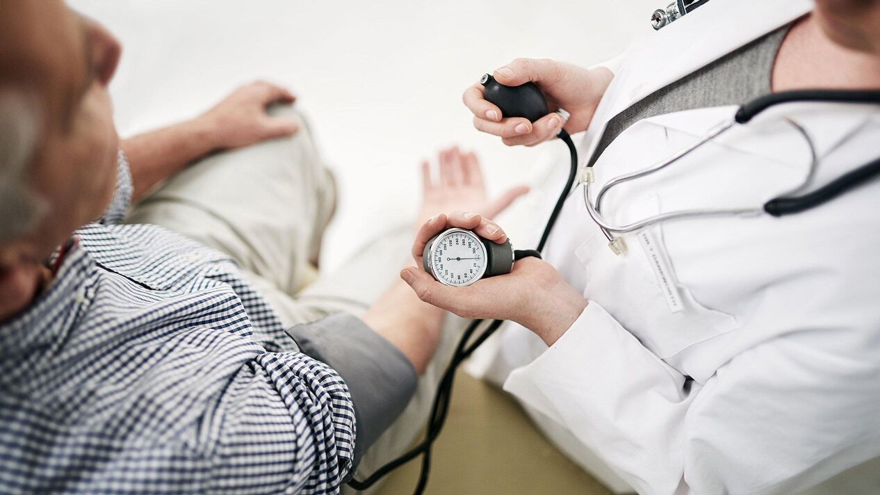 A cardiologist measures blood pressure for a patient with signs of hypertension